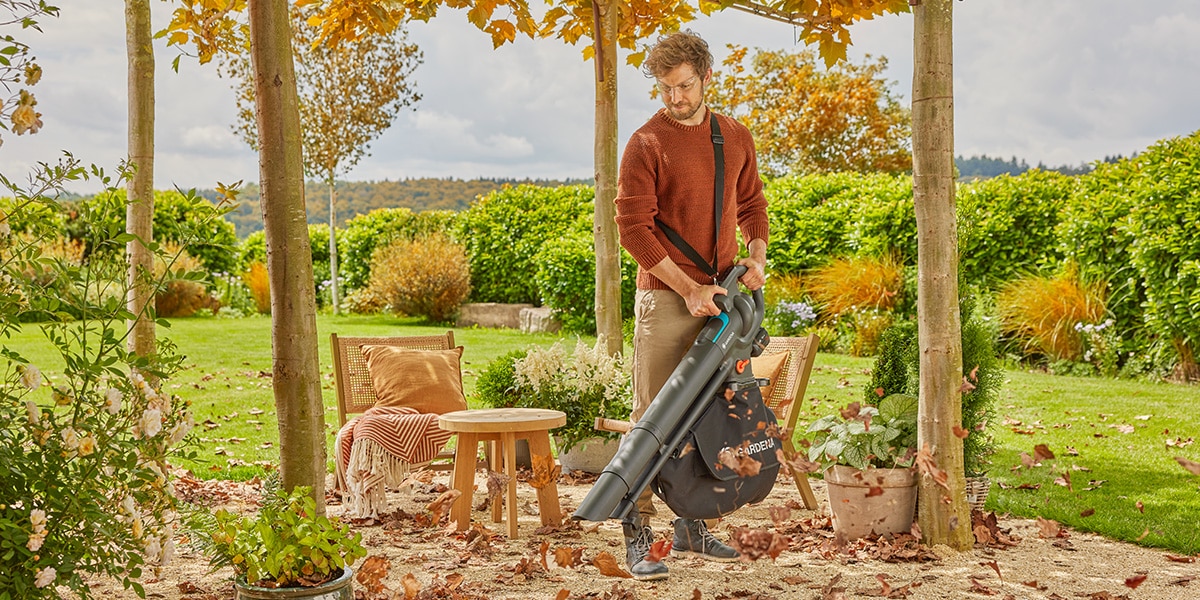 Man met GARDENA bladblazer aan het werk in de tuin